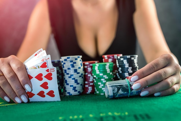 A mulher bonita no vestido preto da noite ganha o dinheiro do pôquer no casino