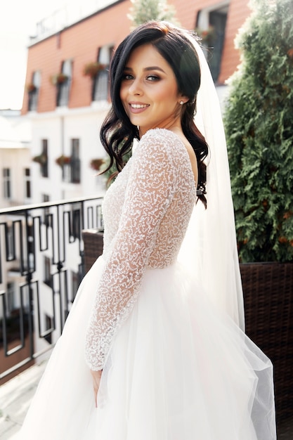 A mulher bonita posando em um vestido de noiva
