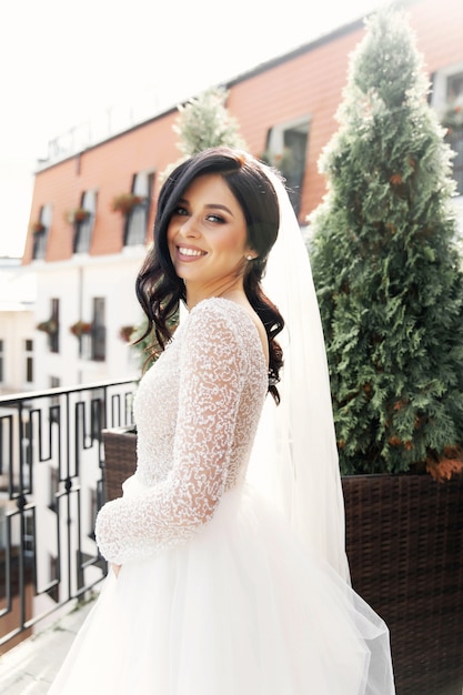 A mulher bonita posando em um vestido de noiva