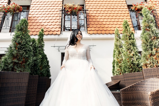 A mulher bonita posando em um vestido de noiva