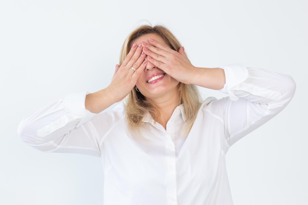 A mulher bonita positiva alegre faz a palma da cara fecha os olhos e sorri alegremente com os dentes Emoções e sonhos conceito de felicidade