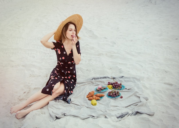 A mulher bonita tem um descanso em uma praia perto de um mar.