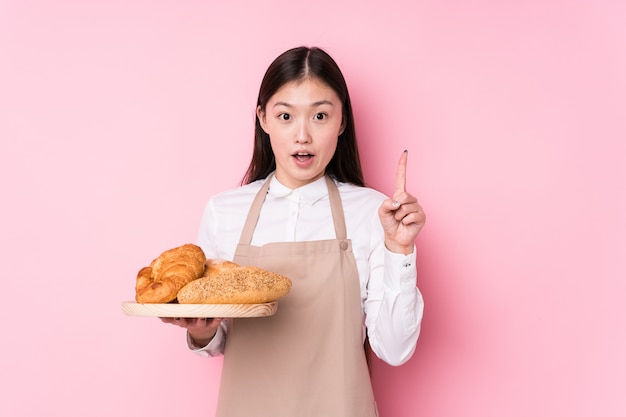 A mulher chinesa nova do padeiro isolou-se tendo alguma grande ideia, conceito da faculdade criadora.