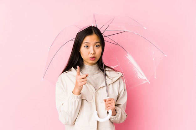 A mulher chinesa nova que guarda um guarda-chuva isolou tendo uma ideia, conceito da inspiração.