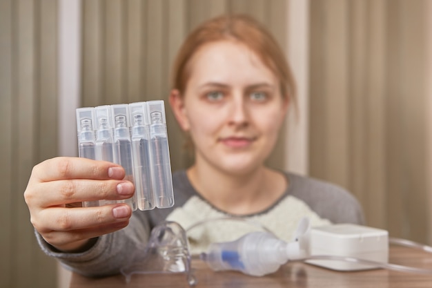 A mulher com dpoc começará a respirar pela câmara de nebulização e a preparar medicamentos.