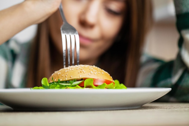 A mulher come alimentos prejudiciais que contribuem para o excesso de peso.