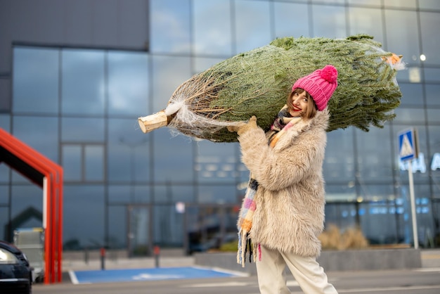 A mulher compra a árvore de natal no shopping