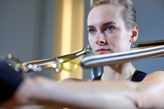 A mulher da ginástica pilates o esporte do esticão na menina do instrutor da cama do reformista. Foco seletivo nas mãos