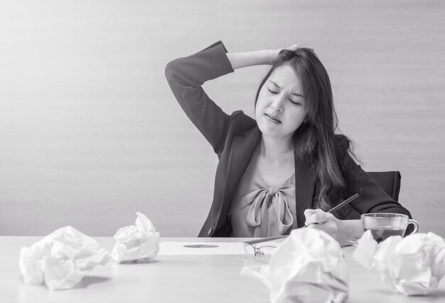 A mulher de funcionamento é forçada do papel de trabalho na frente dela no conceito do trabalho