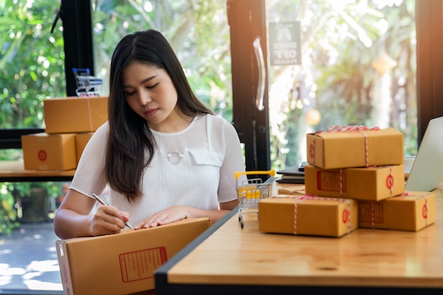 Foto a mulher de negócio prepara a caixa do pacote do produto para entrega ao cliente.