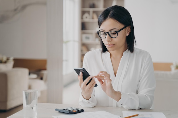 A mulher de negócios está nomeando mensagens de texto de reunião no smartphone Manager ou secretário no local de trabalho