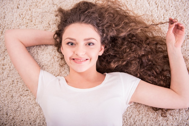 A mulher de sorriso está relaxando colocada no assoalho.