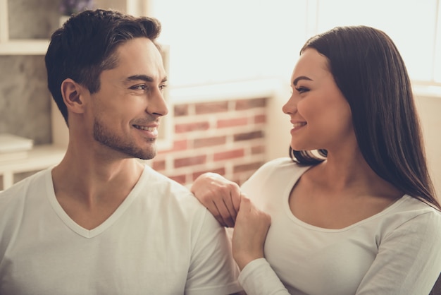 A mulher e o homem novo bonito estão olhando se.