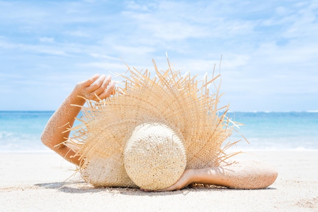 A mulher encontra-se na areia branca na praia