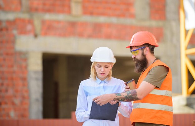 A mulher engenheira e construtora comunicam o canteiro de obras. Conceito de comunicação da equipe de construção. Relacionamentos entre clientes de construção e indústria de construção participante. Discutir o plano de progresso.