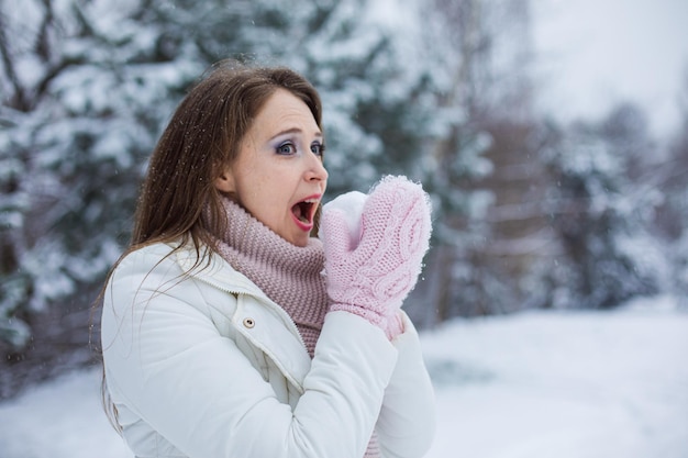 A mulher engraçada tem gosto de neve A mulher de meia-idade vestida com roupas quentes está se divertindo ao ar livre