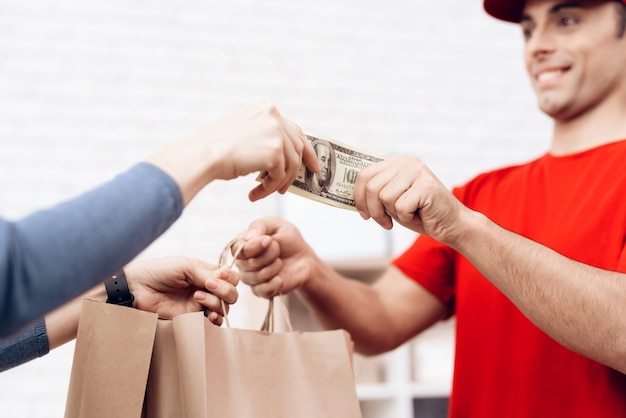 Foto a mulher entrega o dinheiro para o homem de entrega da pizza.