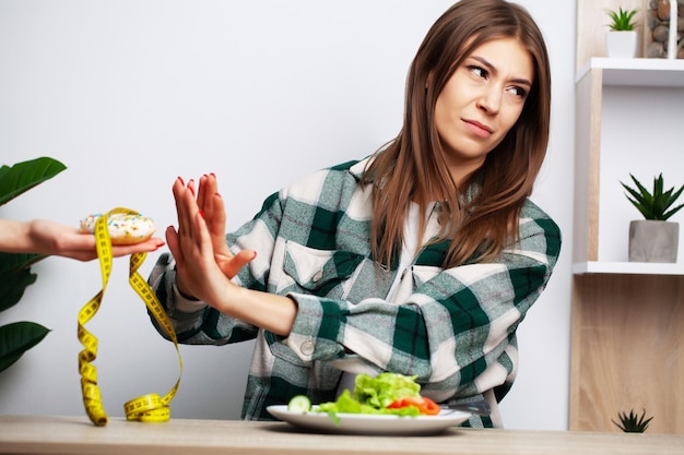 Foto a mulher escolhe entre alimentos saudáveis e prejudiciais.