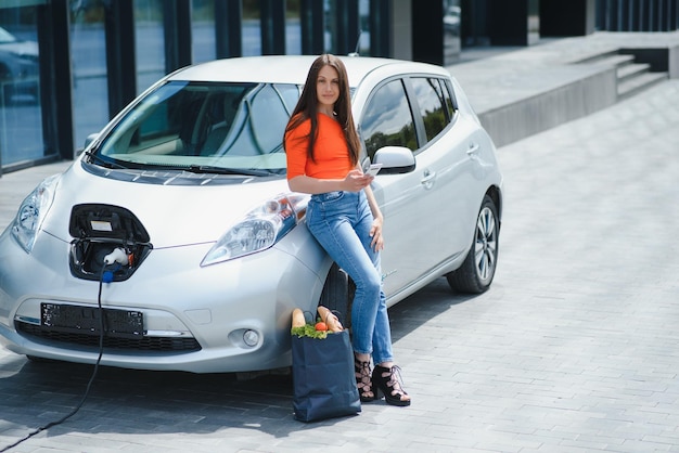 A mulher está carregando o carro elétrico alugado