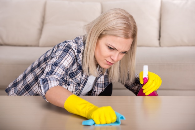 A mulher está fazendo algum trabalho de limpeza na casa.