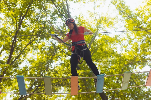 A mulher está fazendo exercício no parque de cordas de aventura