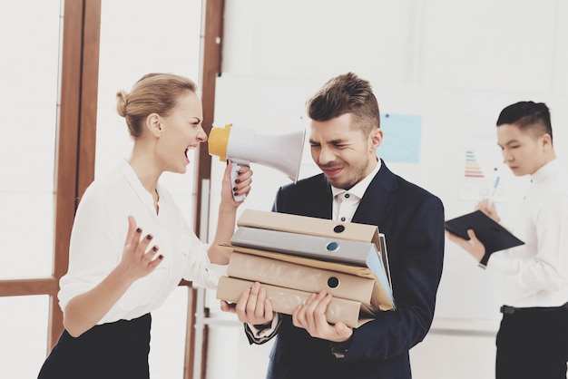 A mulher está gritando no megafone no colega de trabalho no escritório.