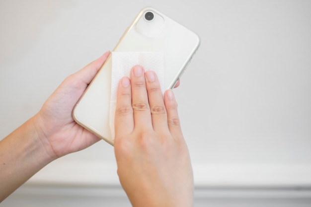 A mulher está limpando o telefone celular