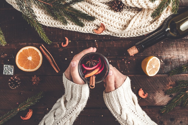 A mulher está prendendo um Natal, vidro de vinho ferventado com especiarias quente.