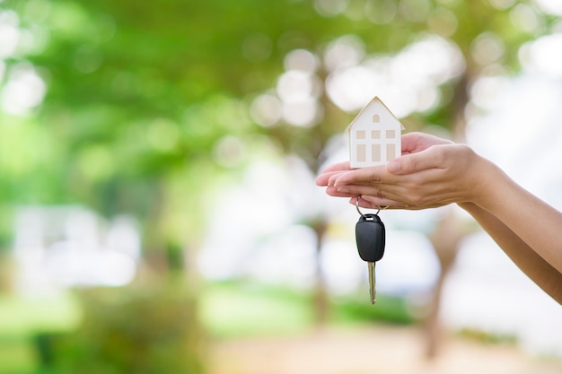 A mulher está segurando a chave da casa e do carro em verde