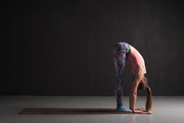 A mulher está trabalhando em pé para a frente ou uttanasana asana