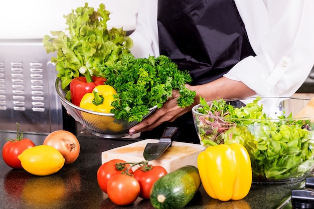 A mulher faz uma salada de legumes frescos