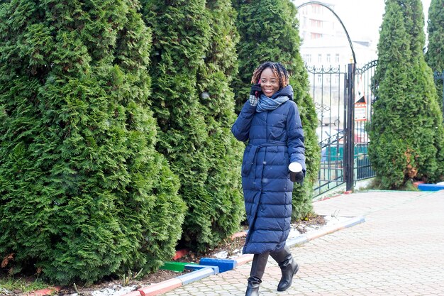 A mulher feliz caminha pela rua no inverno