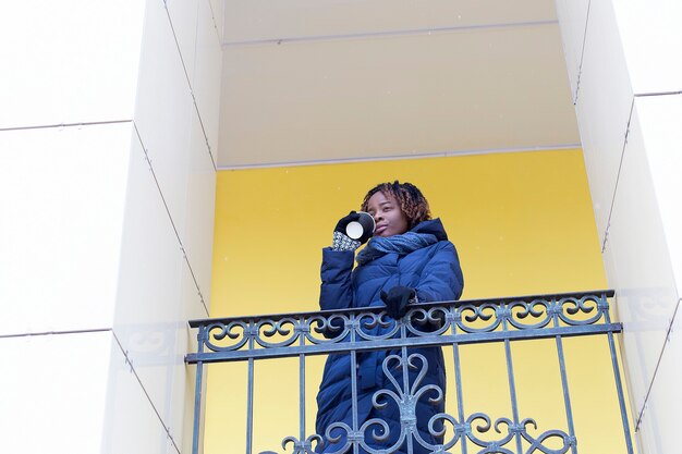 A mulher feliz caminha pela rua no inverno