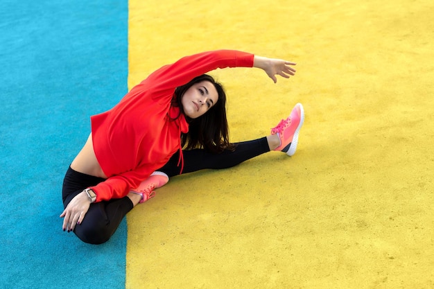 A mulher fitness está se alongando e se exercitando ao ar livre em ambiente urbano