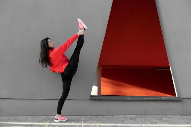 A mulher fitness está se alongando e se exercitando ao ar livre em ambiente urbano