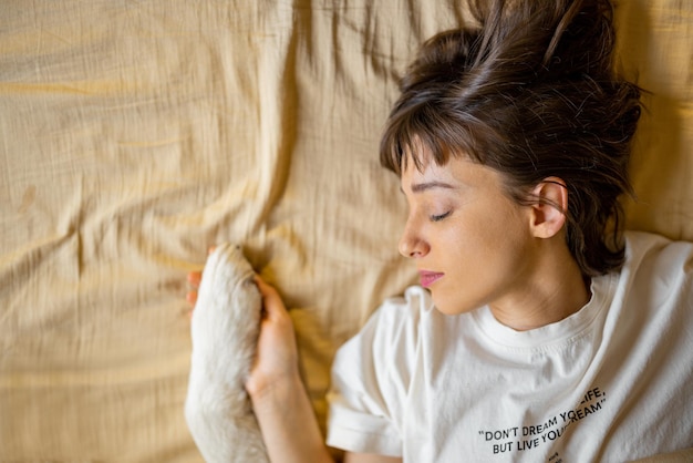 A mulher guarda a pata dos cães na cama