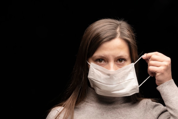 A mulher humana se veste e usa uma máscara protetora contra doenças infecciosas e como proteção contra a poluição ambiental e a gripe. propagação do coronavírus covid 2019.