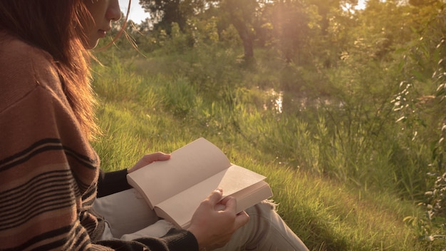 a mulher lendo o livro na natureza.