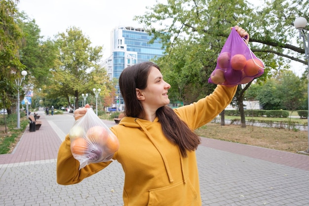 A mulher mantém legumes e frutas em um saco plástico