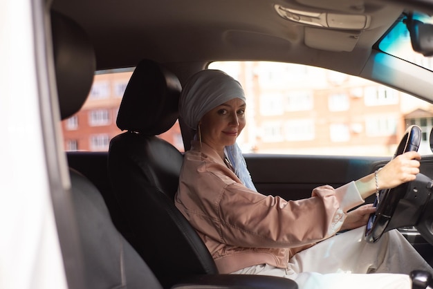 A mulher muçulmana Cutr está sentada no carro moderno