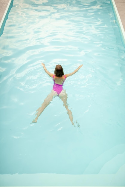 A mulher nada na piscina