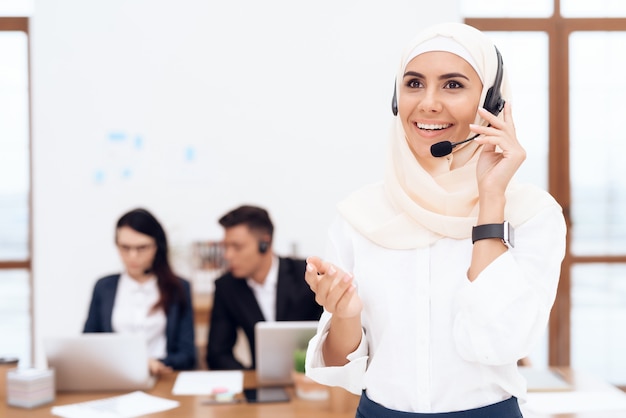 A mulher no hijab fica no centro de atendimento.