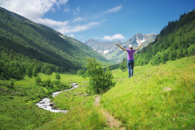 A mulher nova aprecia a natureza da montanha