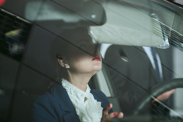 A mulher o volante do carroMulher de negócios no interior do carro através do vidro