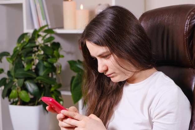 A mulher olha para a tela do telefone