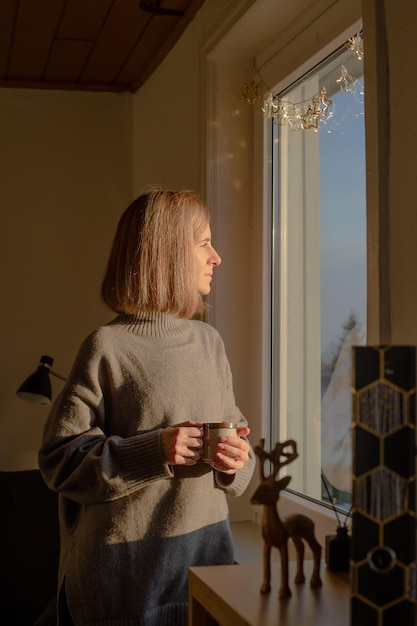 A mulher parece pensativa na janela Paz e atenção plena