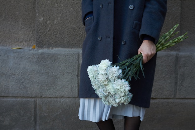 A mulher prende o ramalhete floral ao ar livre