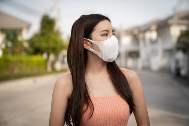 A mulher que usa a máscara facial de proteção respiratória N95, protege a poluição (PM2.5), poluição atmosférica e vírus.