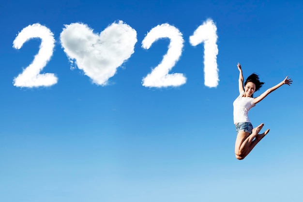 A mulher salta com números de 2021 e símbolo do coração