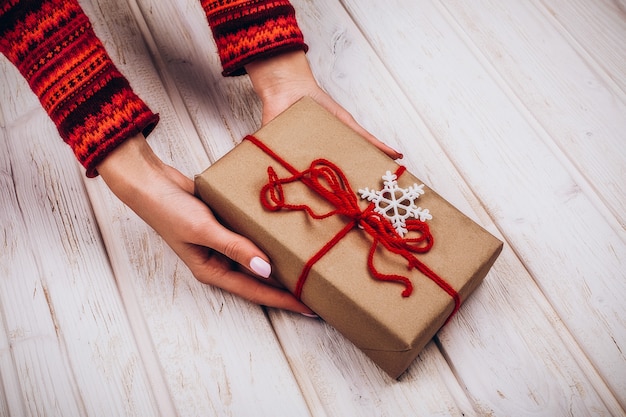 A mulher segura em suas mãos presente para o natal